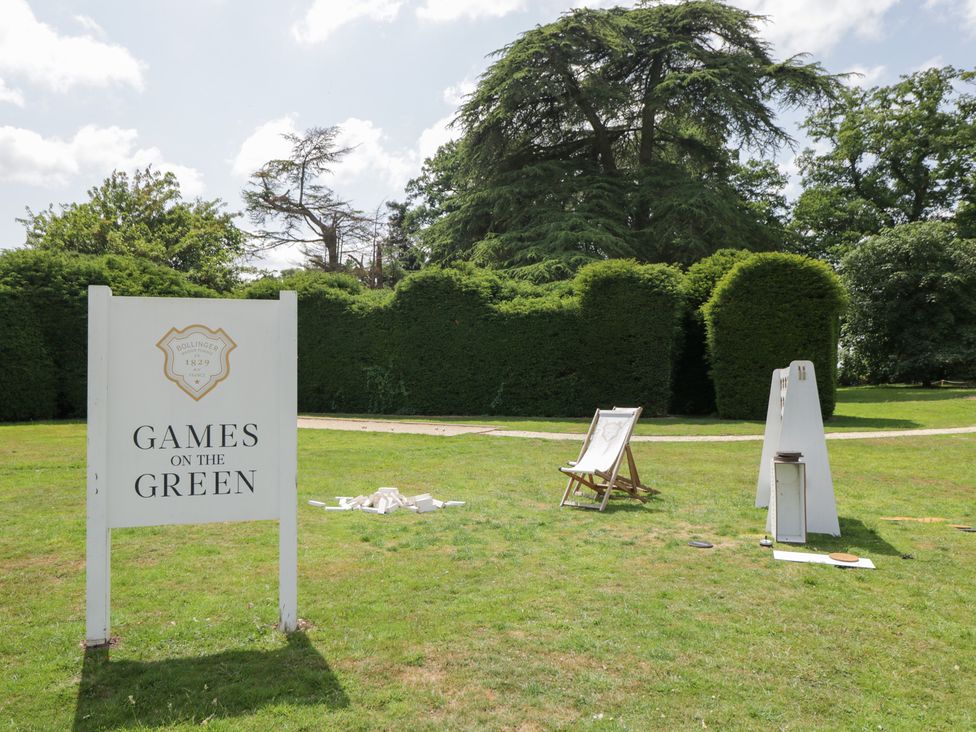 An outdoor games setup with a sign and deck chairs at Cedar Elcot near Newbury