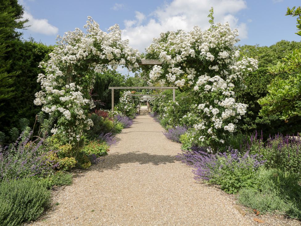 A garden pathway with flowers and an arch at Oak in Elcot near Newbury