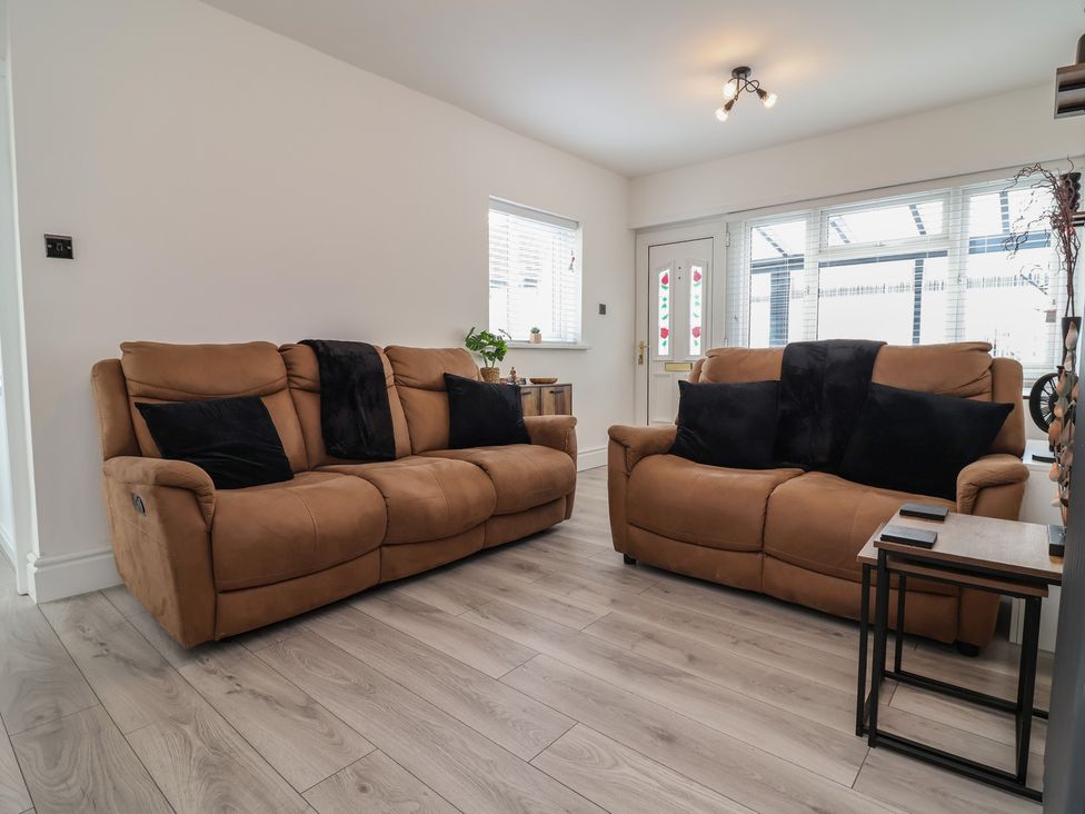 A living room with two sofas and a table at Driftwood in Rhyl