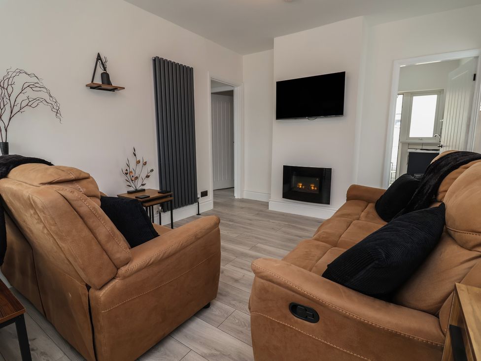 A living room with sofas and a television at Driftwood in Rhyl