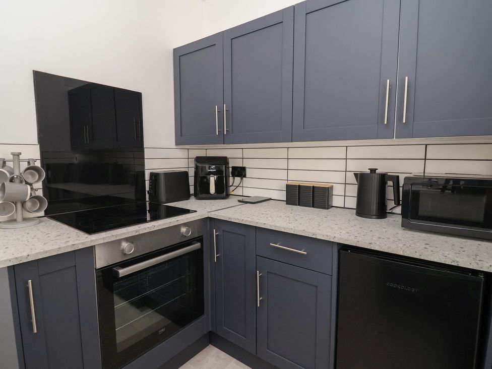 A kitchen with modern appliances and cabinetry at Driftwood in Rhyl