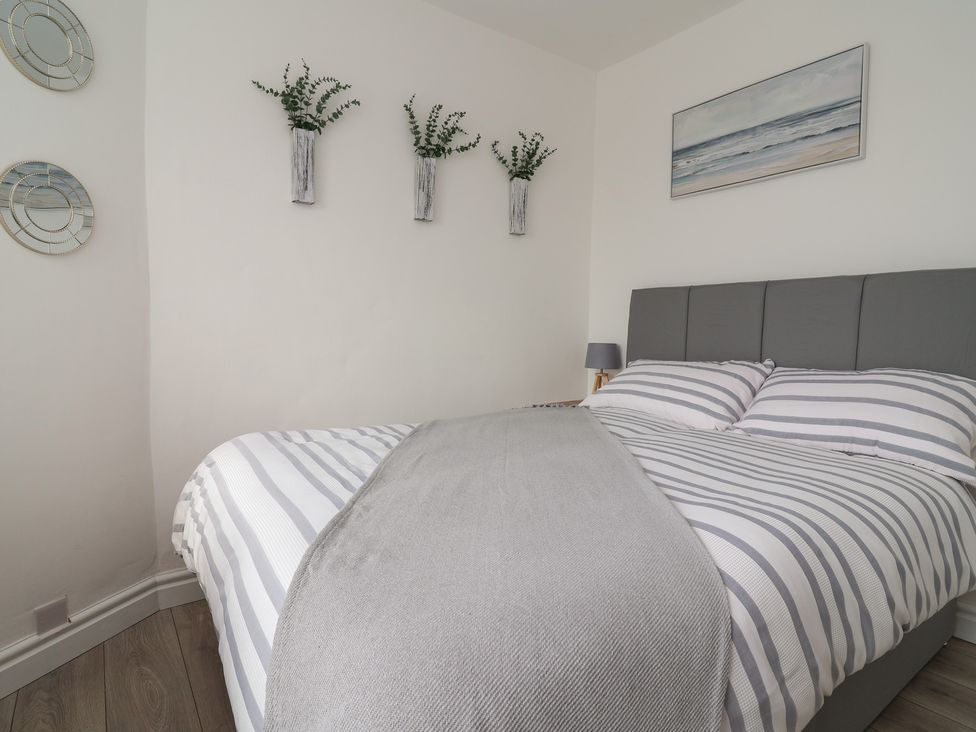 A bedroom with a bed and wall art at Driftwood in Rhyl