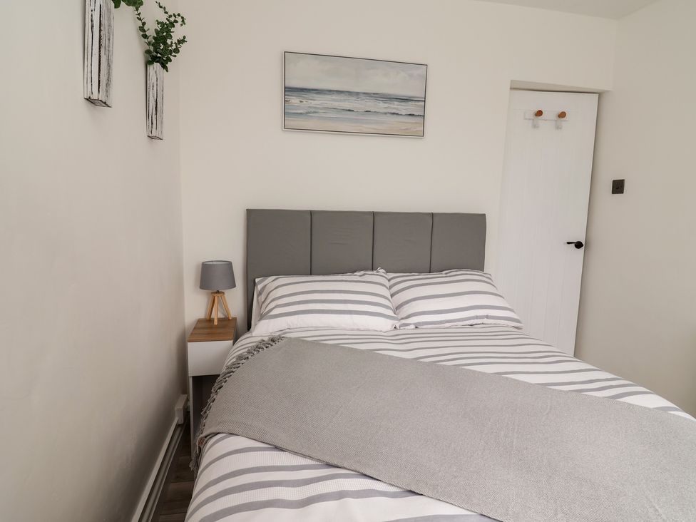 A bedroom with a bed and nightstand at Driftwood in Rhyl
