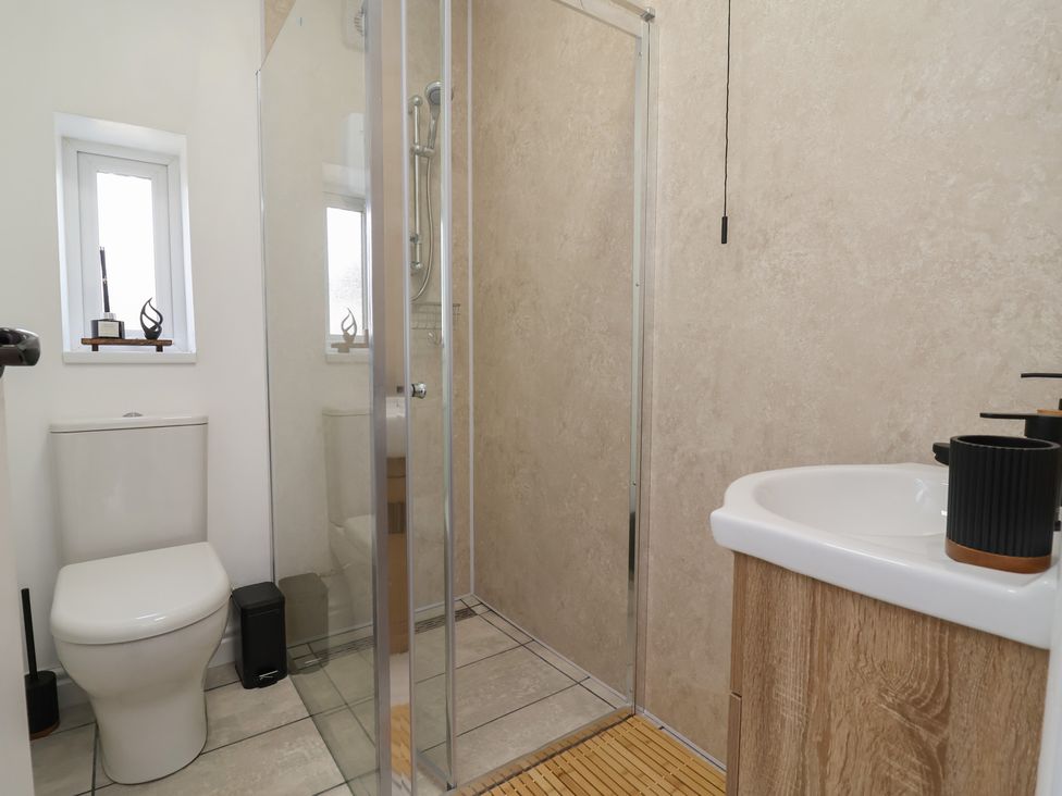 A bathroom with a shower and toilet at Driftwood in Rhyl
