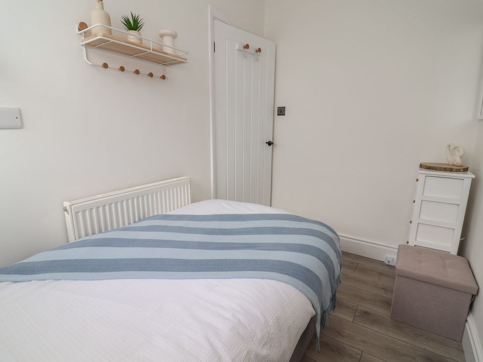 A bedroom with a bed and shelf at Driftwood in Rhyl