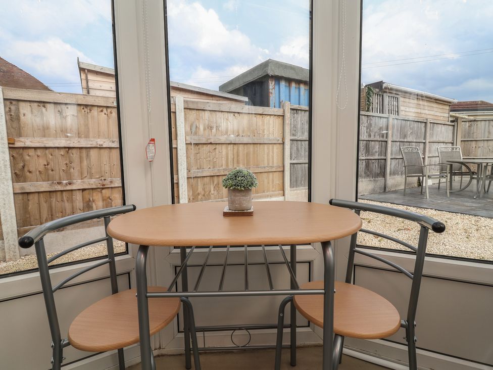 A conservatory with a table and chairs at Driftwood in Rhyl