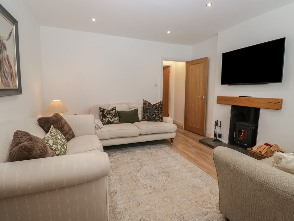 A living room with a sofa and fireplace at Highfield Cottage in Windermere