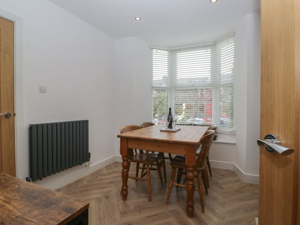 A dining room with a wooden table and chairs at Highfield Cottage in Windermere