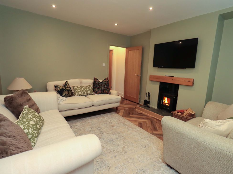 A living room with a sofa and fireplace at Highfield Cottage in Windermere