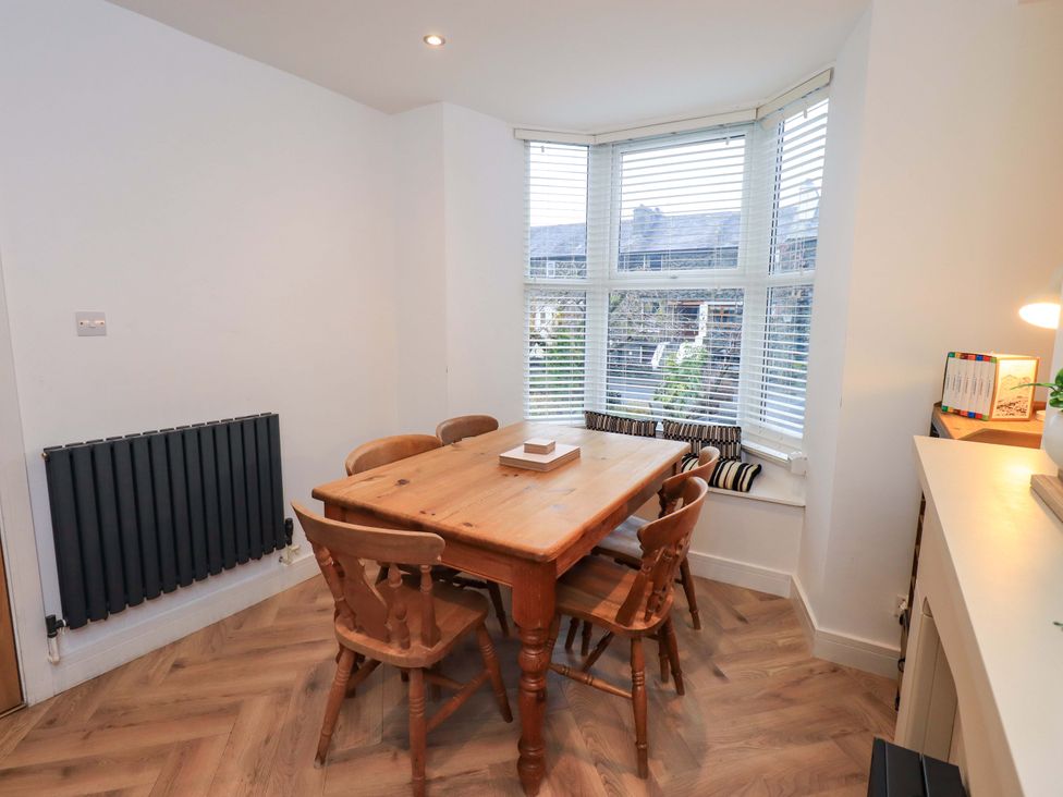 A dining room with a wooden table and chairs at Highfield Cottage in Windermere