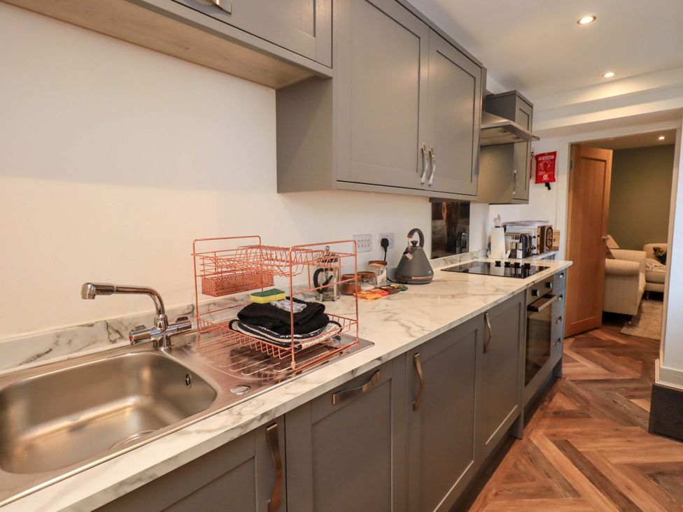 A kitchen with a sink and dish rack at Highfield Cottage in Windermere
