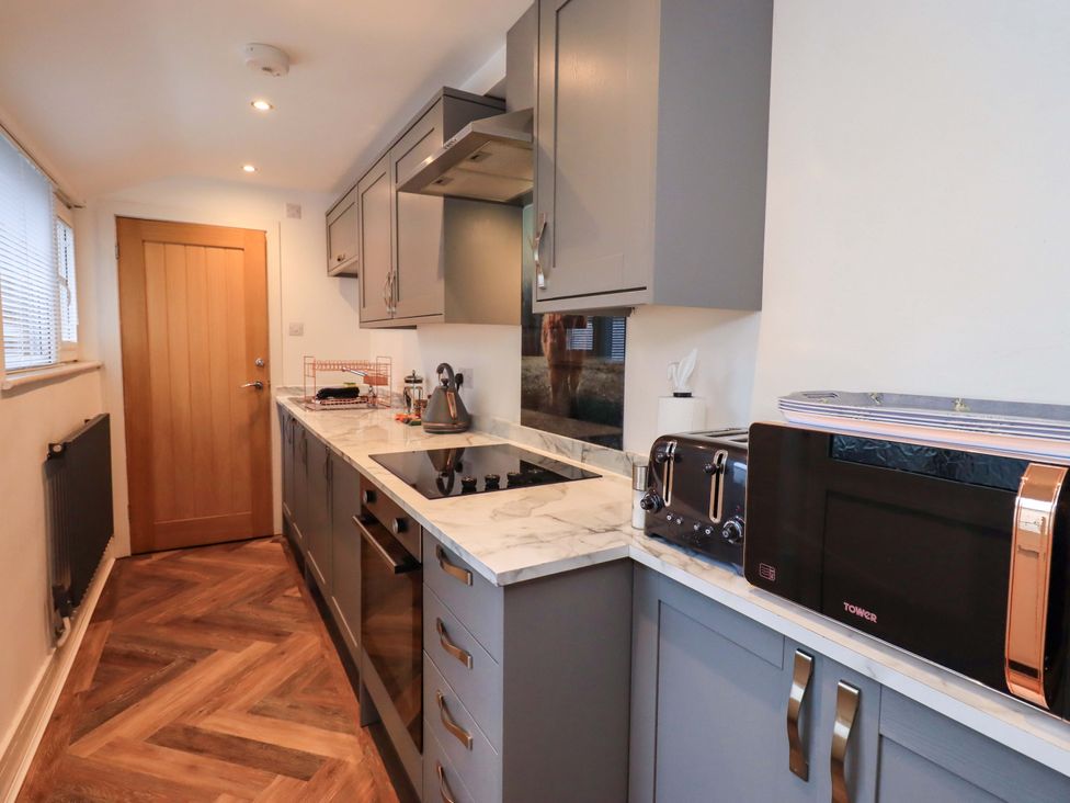 A kitchen with appliances and cabinets at Highfield Cottage in Windermere