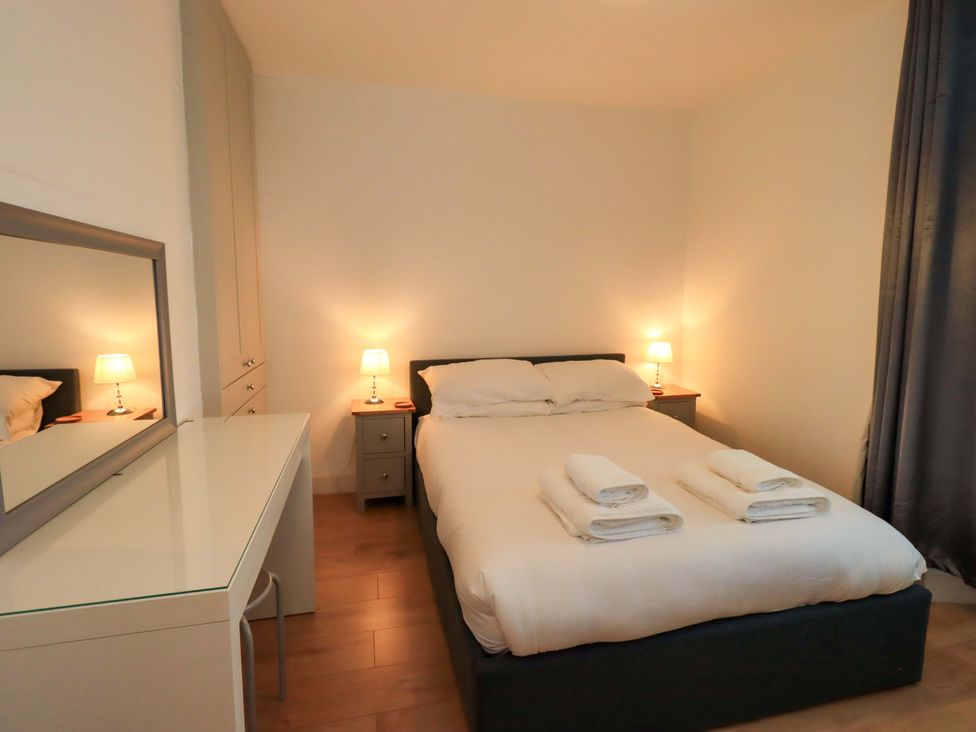 A bedroom with a bed and nightstands at Highfield Cottage in Windermere