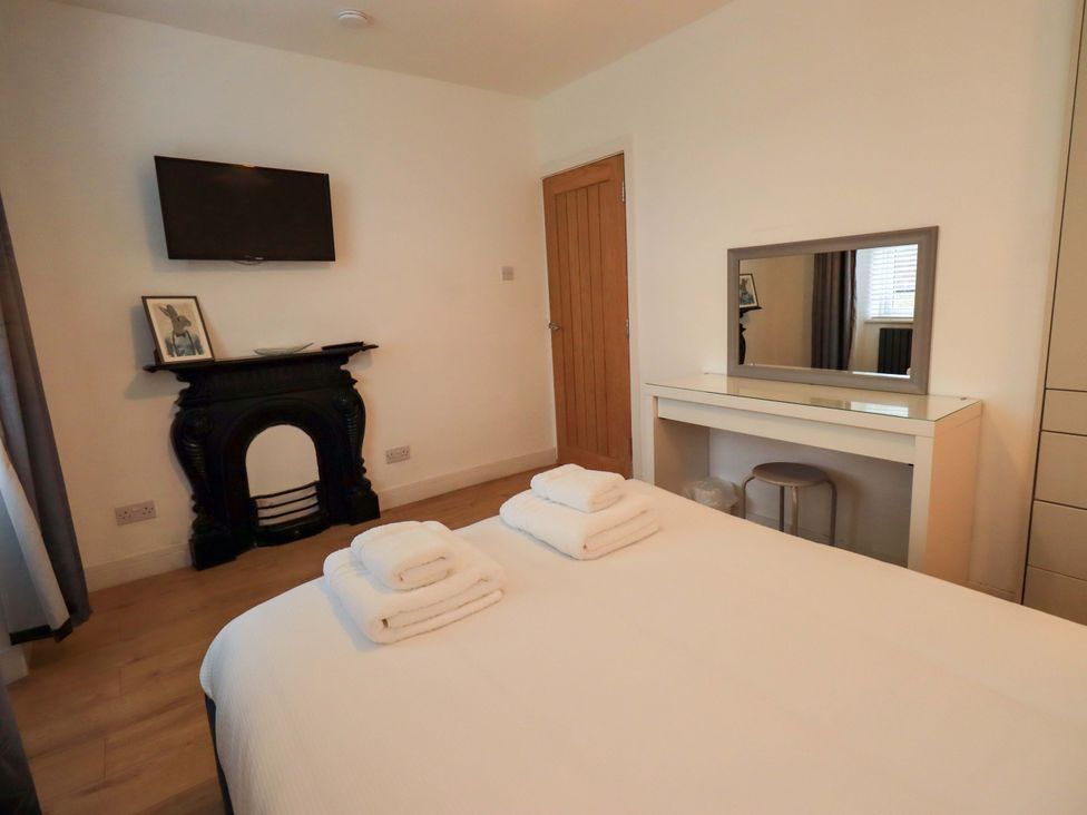 A bedroom with a bed and a television at Highfield Cottage in Windermere