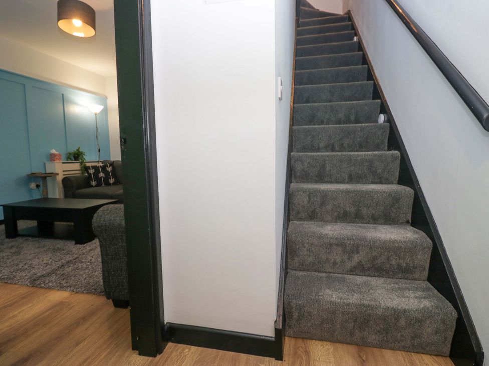 A staircase leading to upper floor with adjacent living room at Havelock Hideaway in Windermere