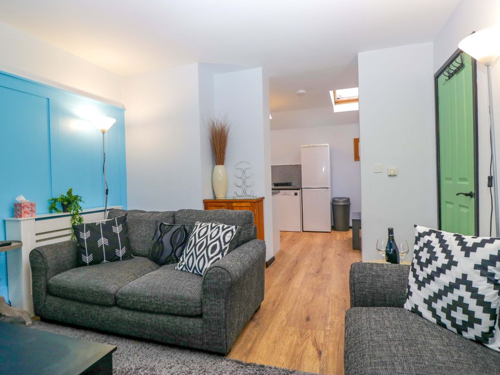 A living room with two sofas and a kitchen area at Havelock Hideaway Windermere