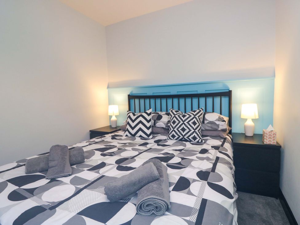 A bedroom with a bed and bedside table at Havelock Hideaway in Windermere