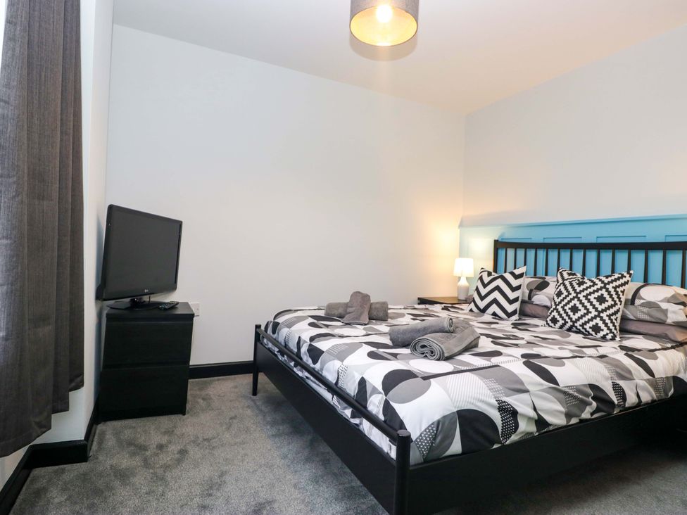 A bedroom with a bed and television at Havelock Hideaway in Windermere