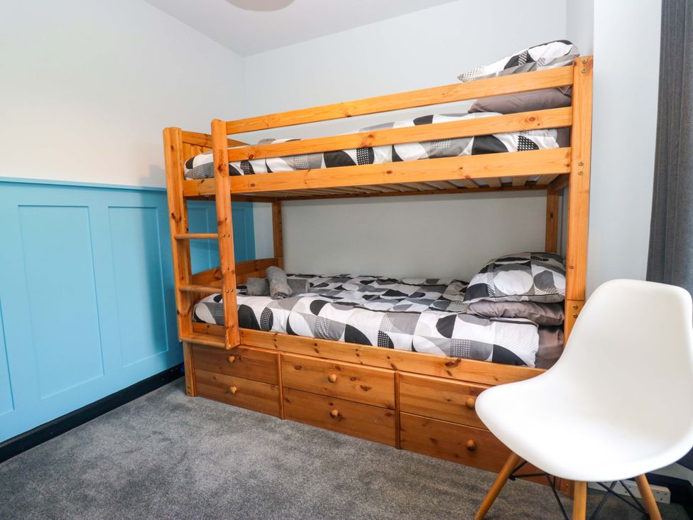 A bedroom with a bunk bed and a chair at Havelock Hideaway in Windermere