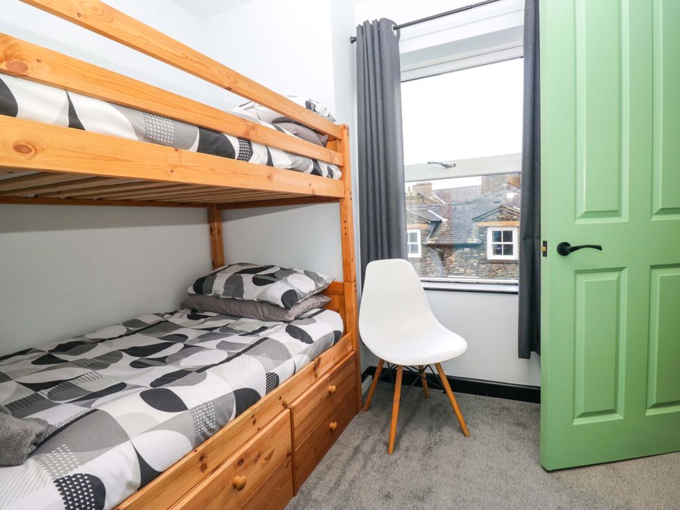 A bedroom with a bunk bed and a chair at Havelock Hideaway in Windermere