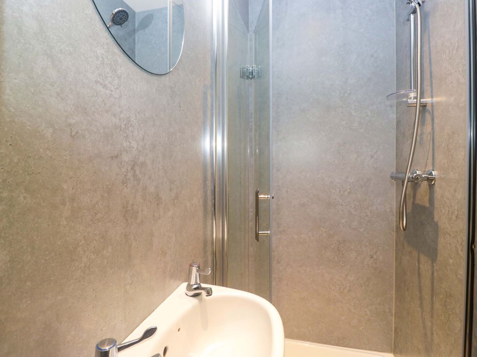 A bathroom with a shower and sink at Havelock Hideaway in Windermere