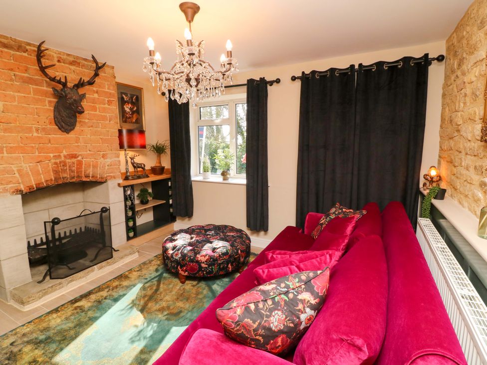 A living room with a fireplace and a sofa at 7 The Row in Grantham