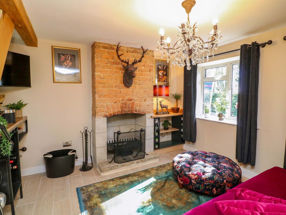 A living room with a fireplace and chandelier at 7 The Row in Grantham