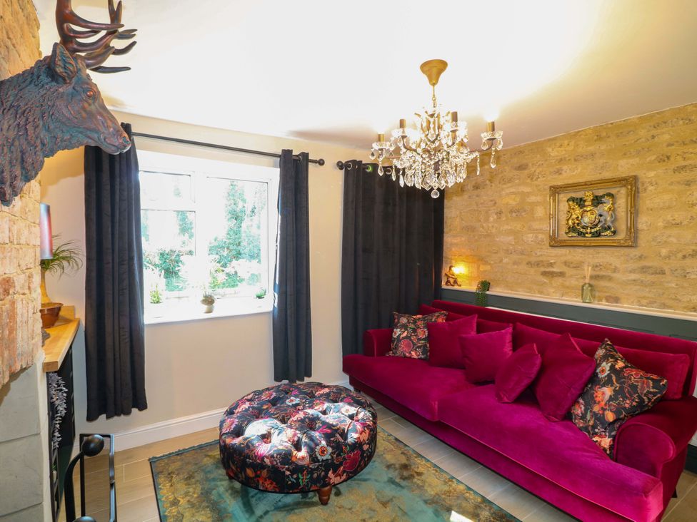 A living room with a pink sofa and chandelier at 7 The Row Grantham