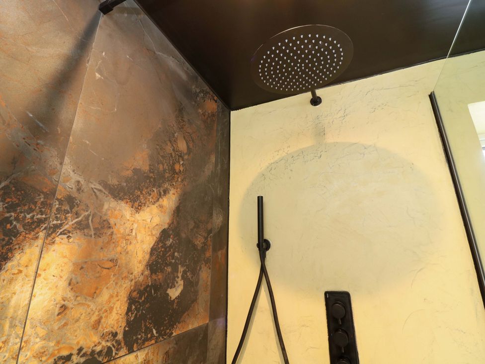 A shower area with a shower head and wall features at 7 The Row Grantham