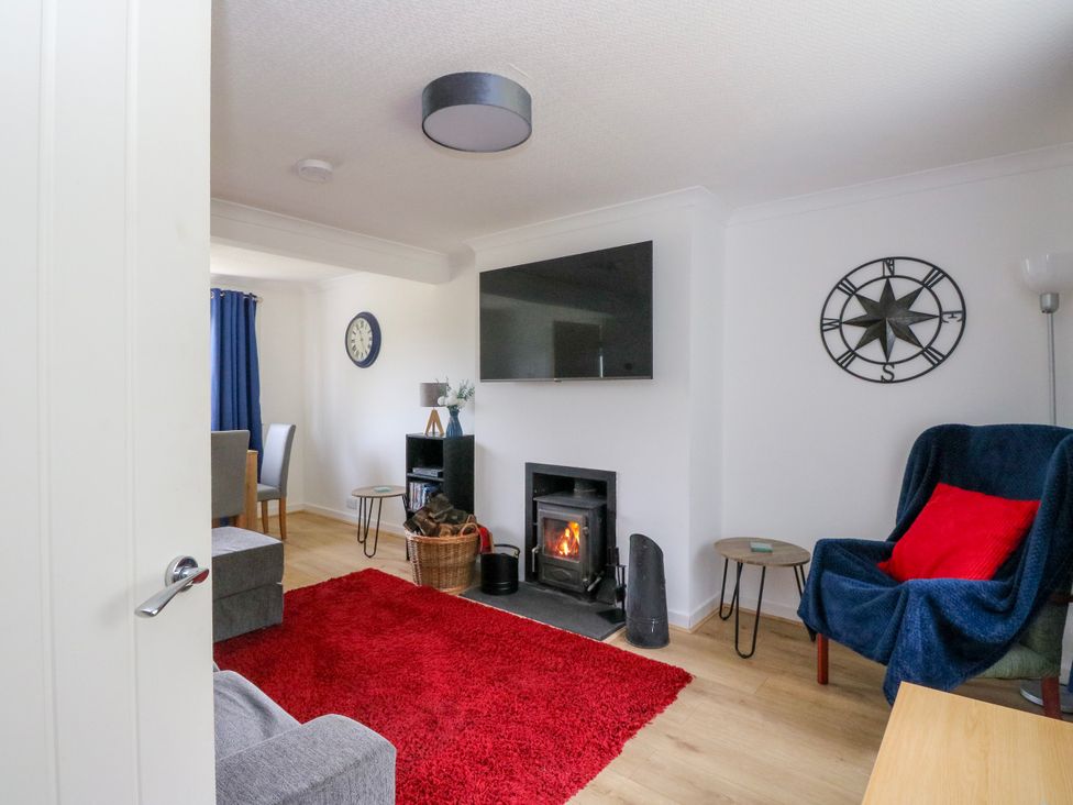 A living room with a fireplace and television at 3 Whin Bank Clachan-Seil near Balvicar Isle Of Seil