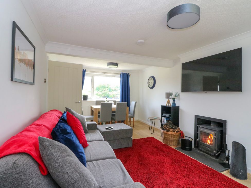 A living room with a sofa and a dining area at 3 Whin Bank near Balvicar, Isle Of Seil