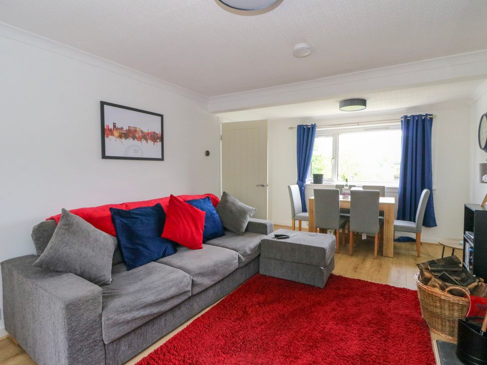 A living room with a sofa and dining area at 3 Whin Bank Clachan-Seil near Balvicar Isle Of Seil