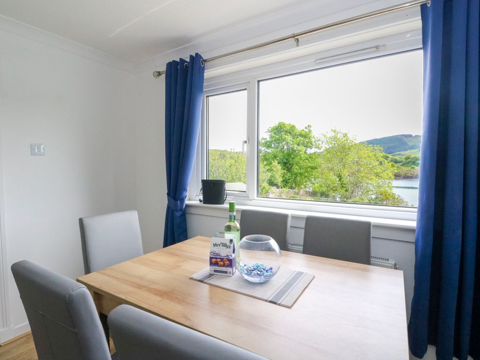 A dining room with a table and chairs at 3 Whin Bank Clachan-Seil near Balvicar Isle Of Seil