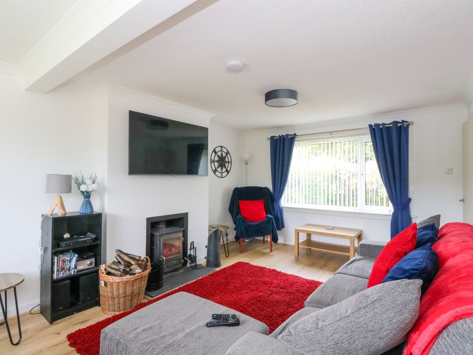A living room with a television and fireplace at 3 Whin Bank, Clachan-Seil near Balvicar, Isle Of Seil