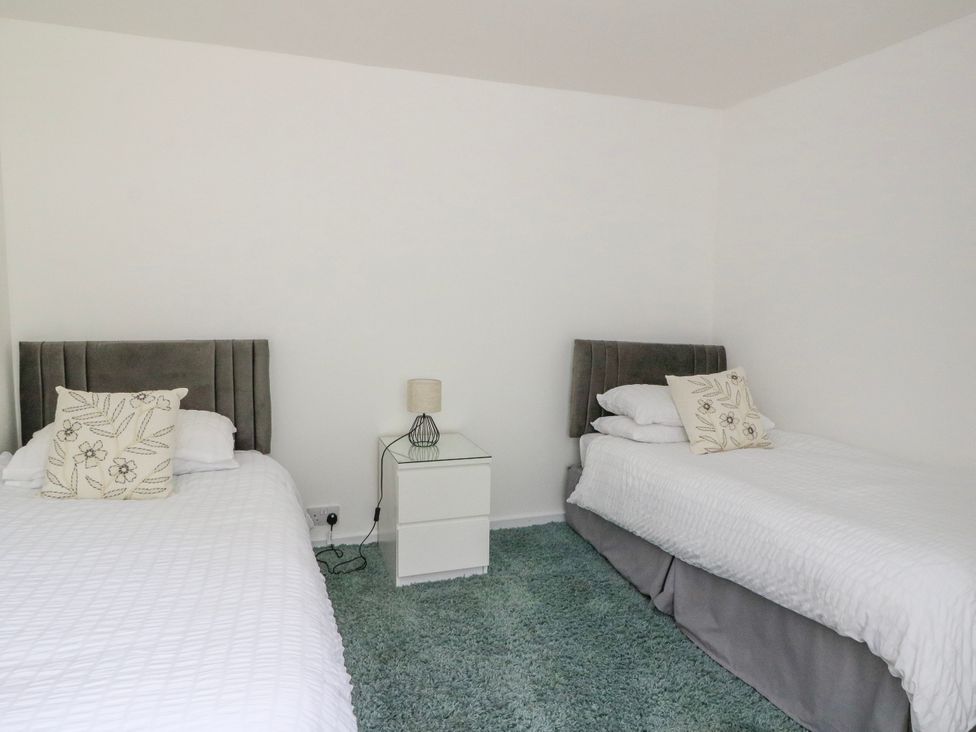 A bedroom with two beds and a bedside table at 3 Whin Bank Clachan-Seil near Balvicar Isle Of Seil