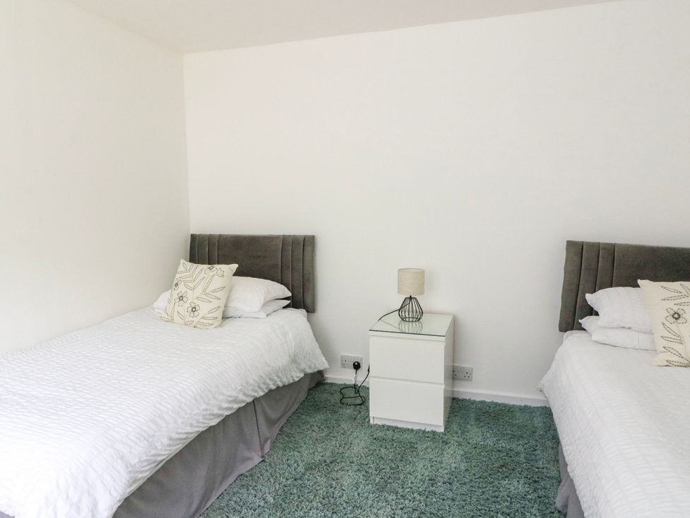 A bedroom with two single beds and a nightstand at 3 Whin Bank Clachan-Seil near Balvicar Isle Of Seil