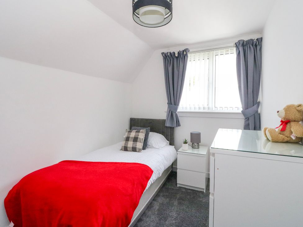 A bedroom with a bed, window, lamp, and furniture at 3 Whin Bank Clachan-Seil near Balvicar, Isle Of Seil