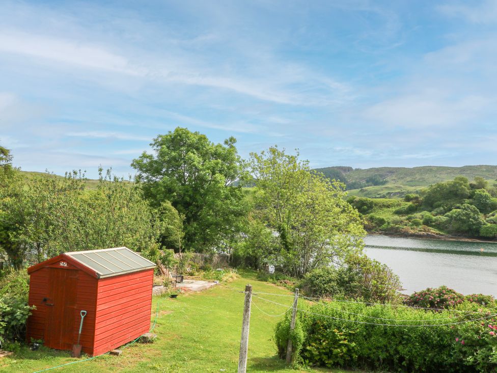 A shed near water with trees and grass at 3 Whin Bank Clachan-Seil near Balvicar Isle Of Seil
