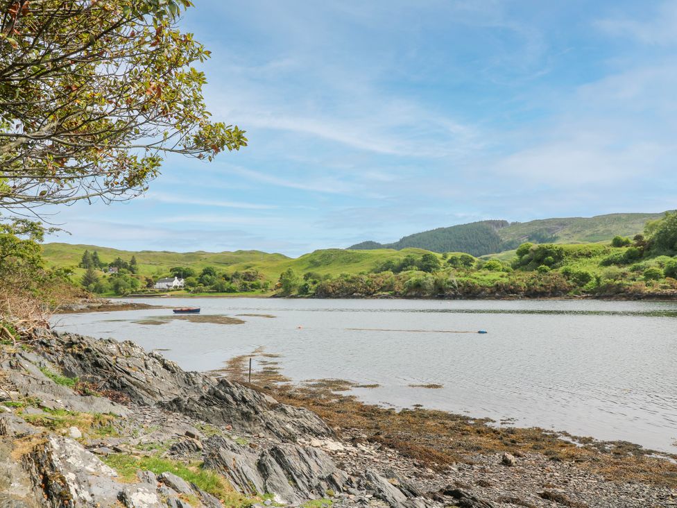 A view of water with a boat and hills at 3 Whin Bank Clachan-Seil near Balvicar Isle Of Seil