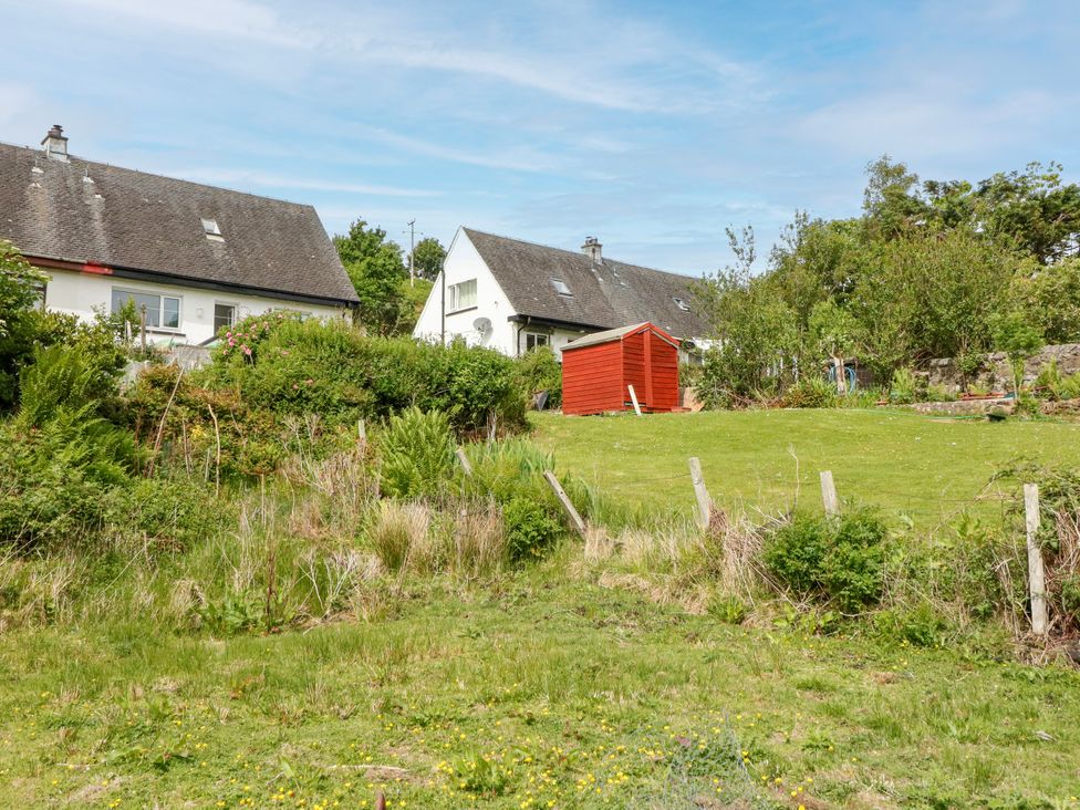 A garden with two houses and a red shed at 3 Whin Bank, Clachan-Seil near Balvicar, Isle Of Seil
