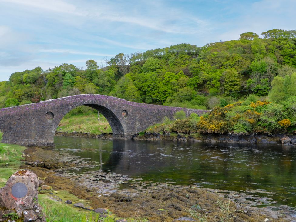 A bridge over a river with trees in the background at 3 Whin Bank, Clachan-Seil near Balvicar, Isle Of Seil