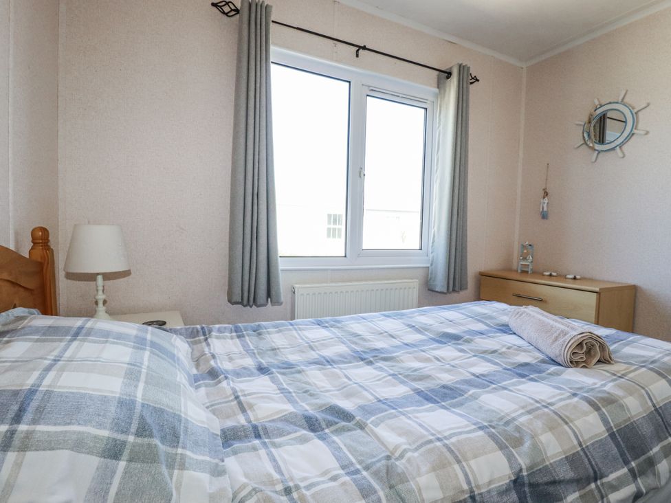 A bedroom with a bed and lamp at Lazy Days St Merryn
