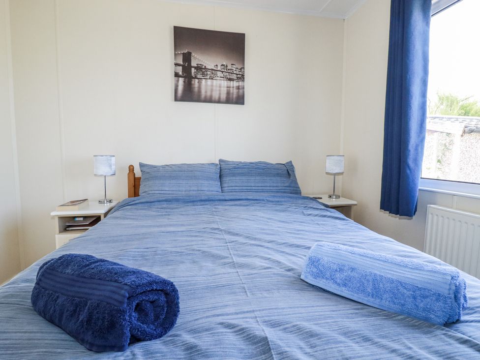 A bedroom with a bed and decorative wall art at Lazy Days in St Merryn