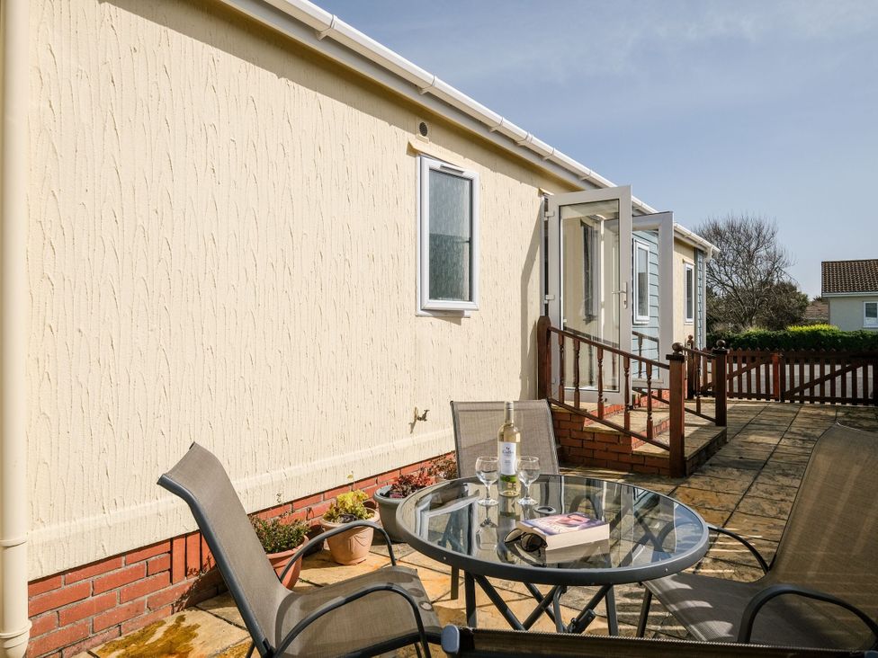 A patio area with a table and chairs at Lazy Days in St Merryn