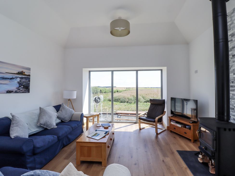 A living room with a sofa and television at West Burton Hemmel in Bamburgh