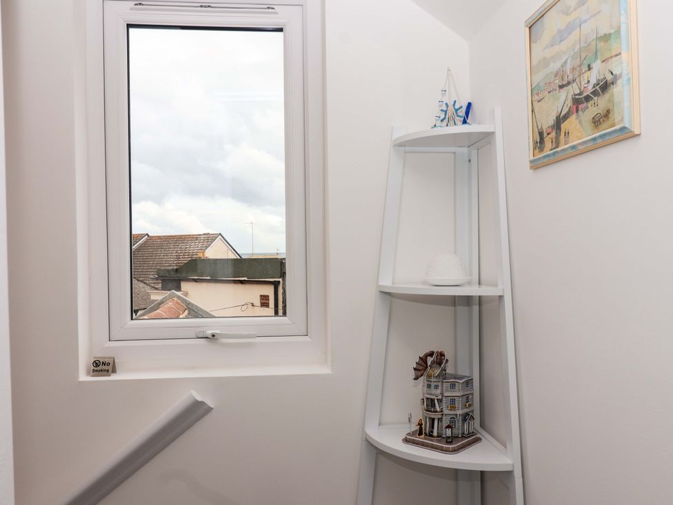 A stairwell with a window and a decorative shelf at Lilly's Cottage Dawlish