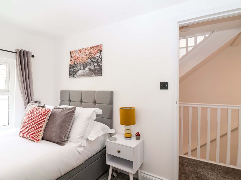 A bedroom with a bed and lamp at Lilly's Cottage in Dawlish