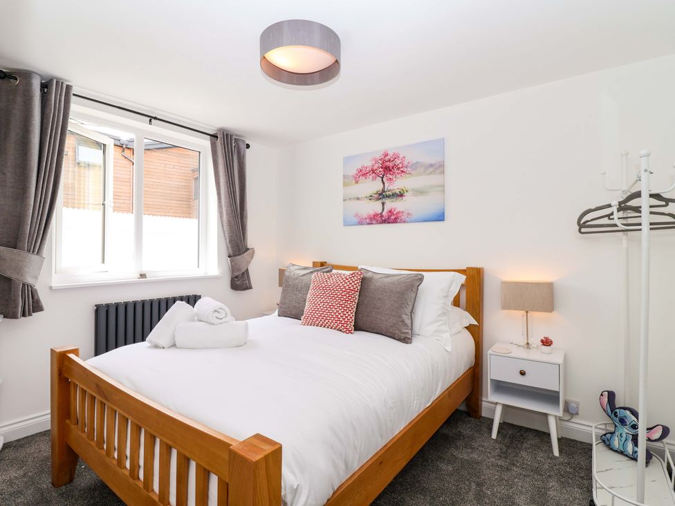 A bedroom with a bed and window at Lilly's Cottage in Dawlish