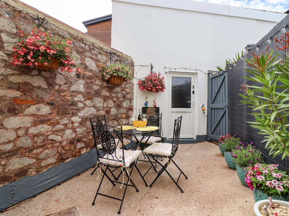 A garden with a table and chairs at Lilly's Cottage in Dawlish