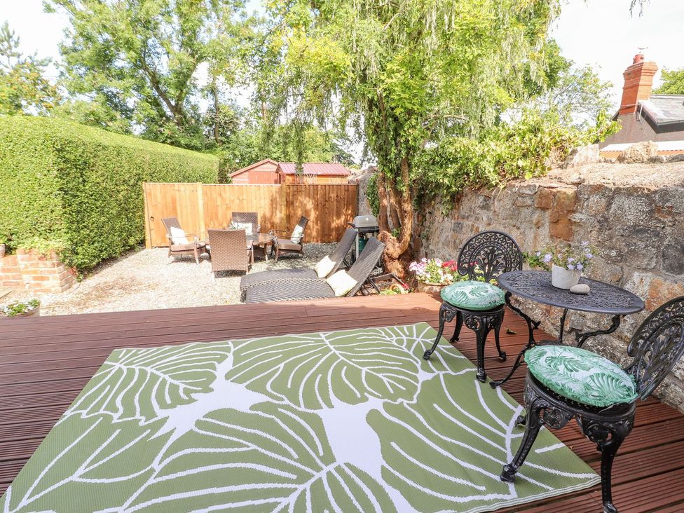 A garden with seating area and greenery at Mount House Bryniau near Dyserth